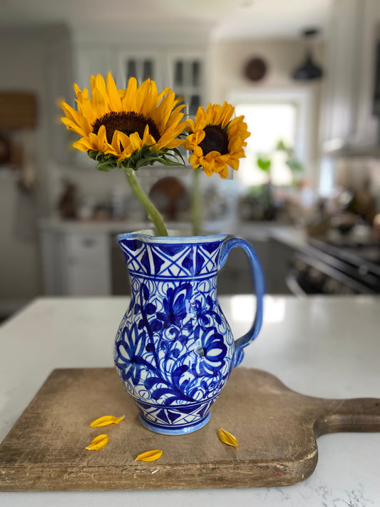 "A bold blue pitcher with a vibrant design, perfect for lemonade or as a decorative vase."