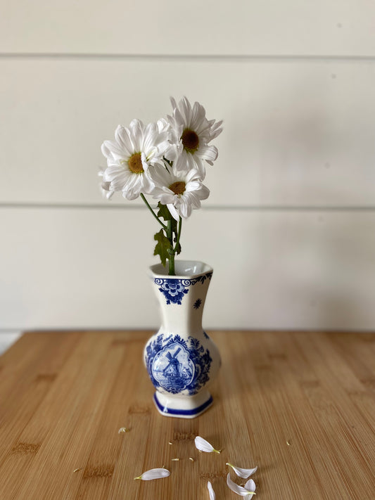 "A vintage blue and white vase featuring beautiful handpainted details."