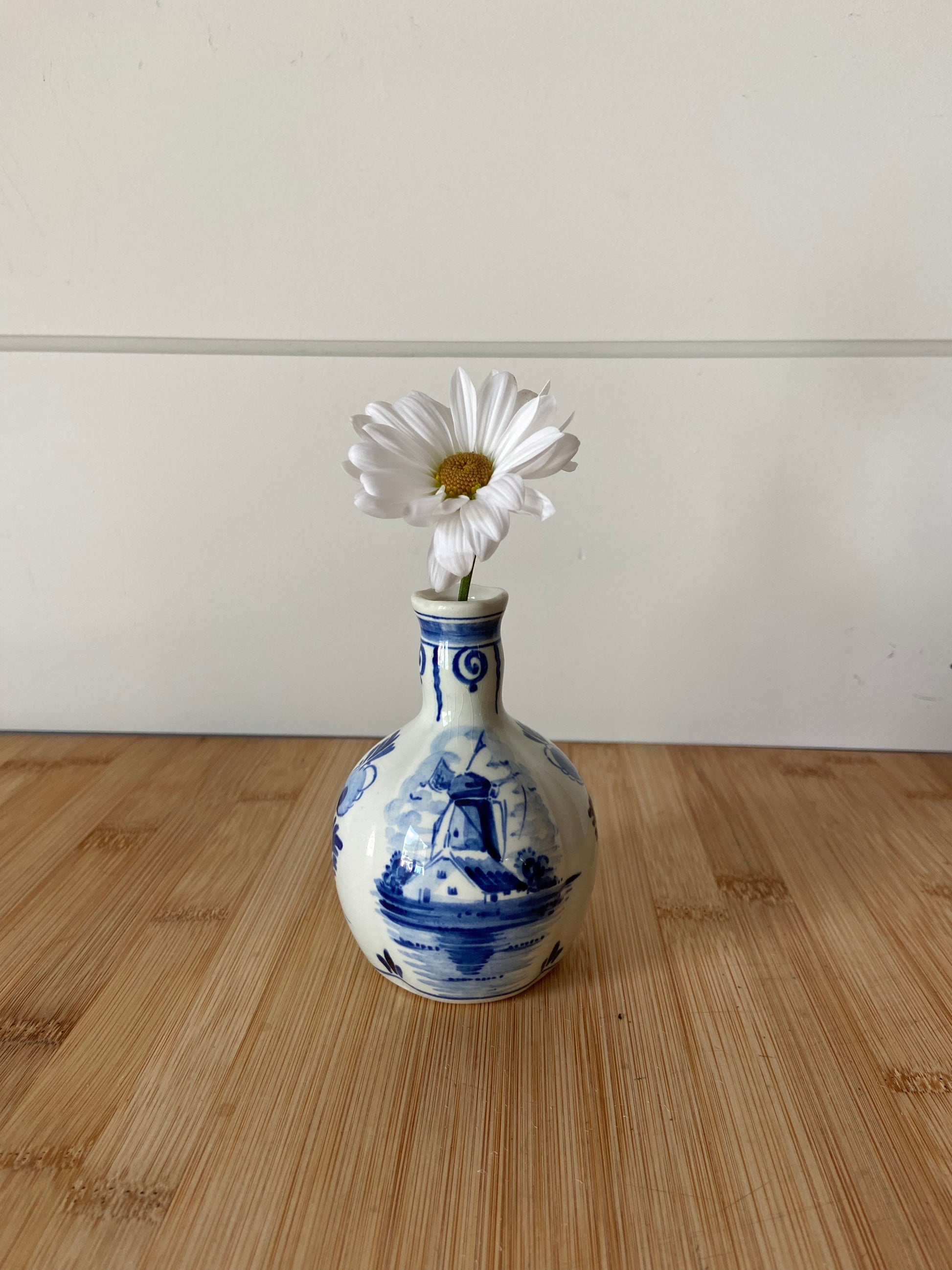 "A charming blue and white vase with intricate handpainted design."