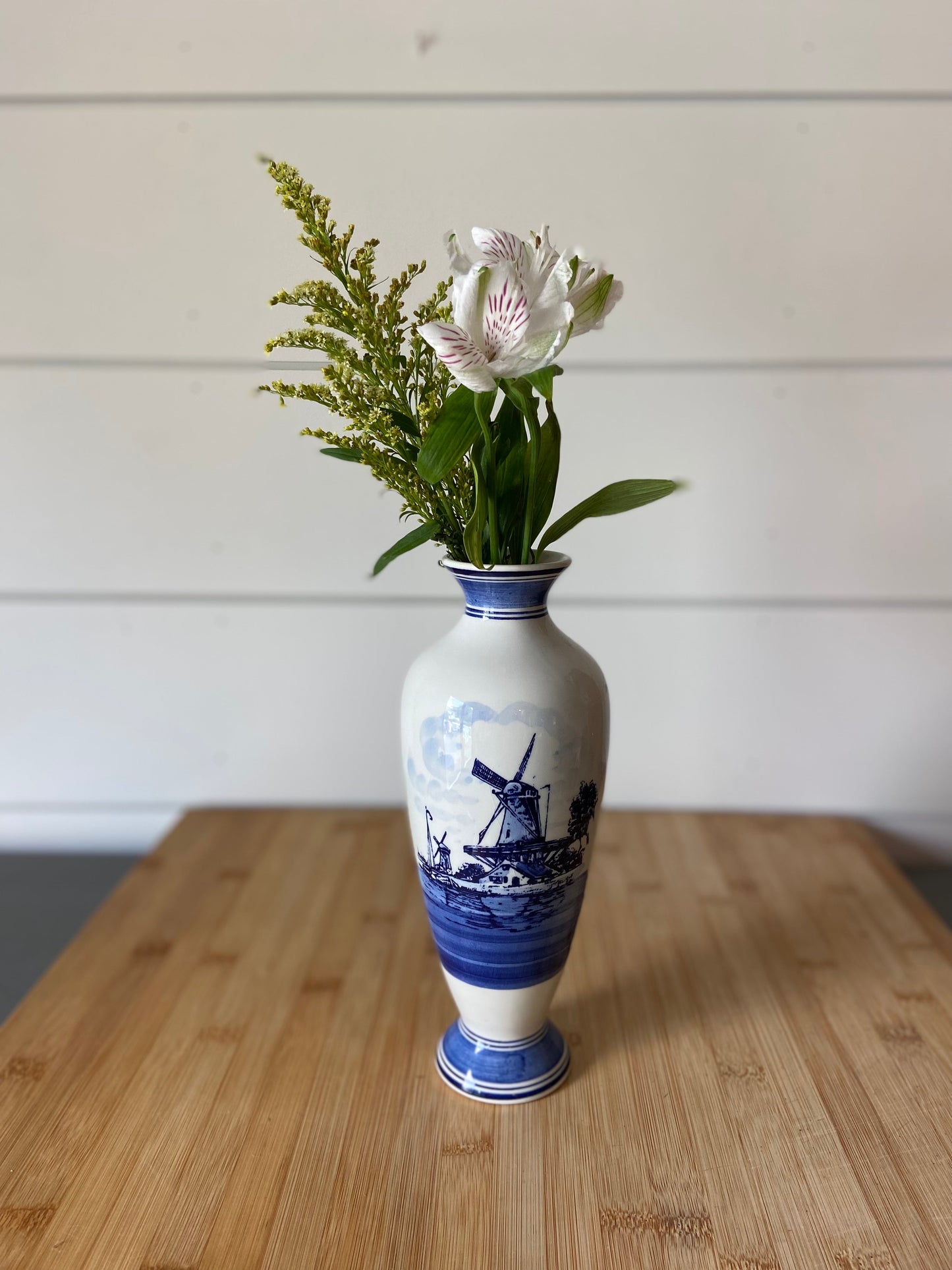 "A vintage blue and white bud vase, handpainted with a floral design."