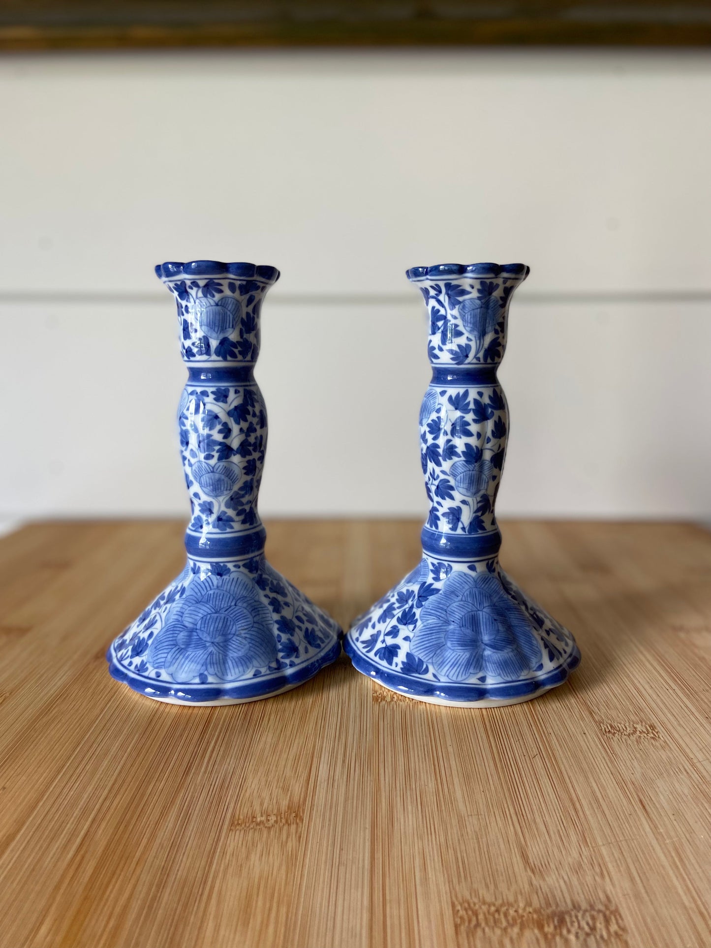 "Two blue and white candle holders handpainted in Thailand, featuring intricate designs."