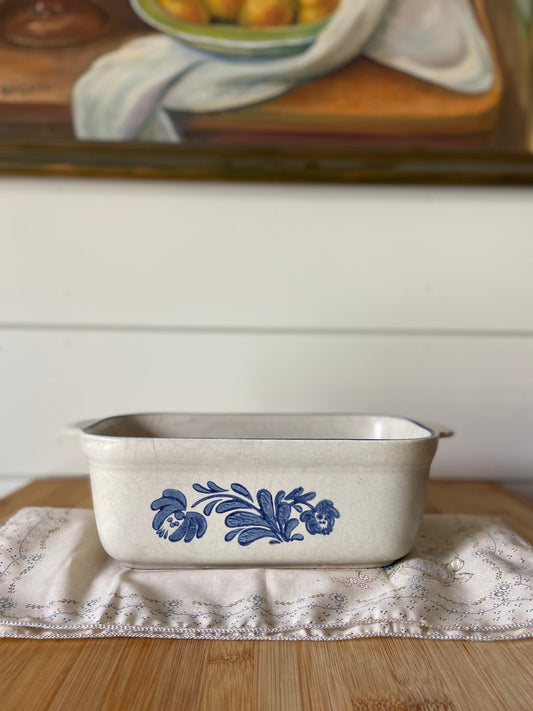 "A blue and white vintage Pfaltgraff loaf pan, perfect for baking bread and adding charm to your kitchen."